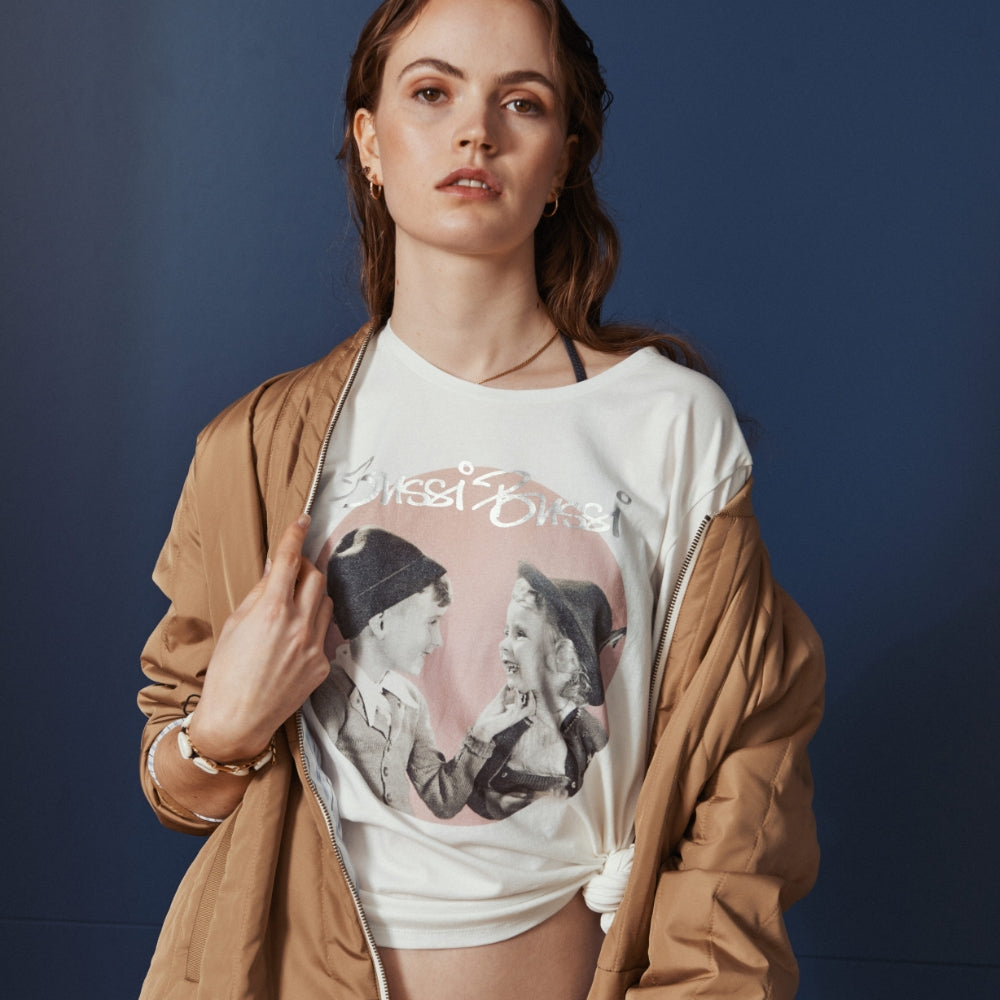 Model trägt Oversized Shirt mit Bussi Bussi Schriftzug lässig mit einem Knoten am Saum